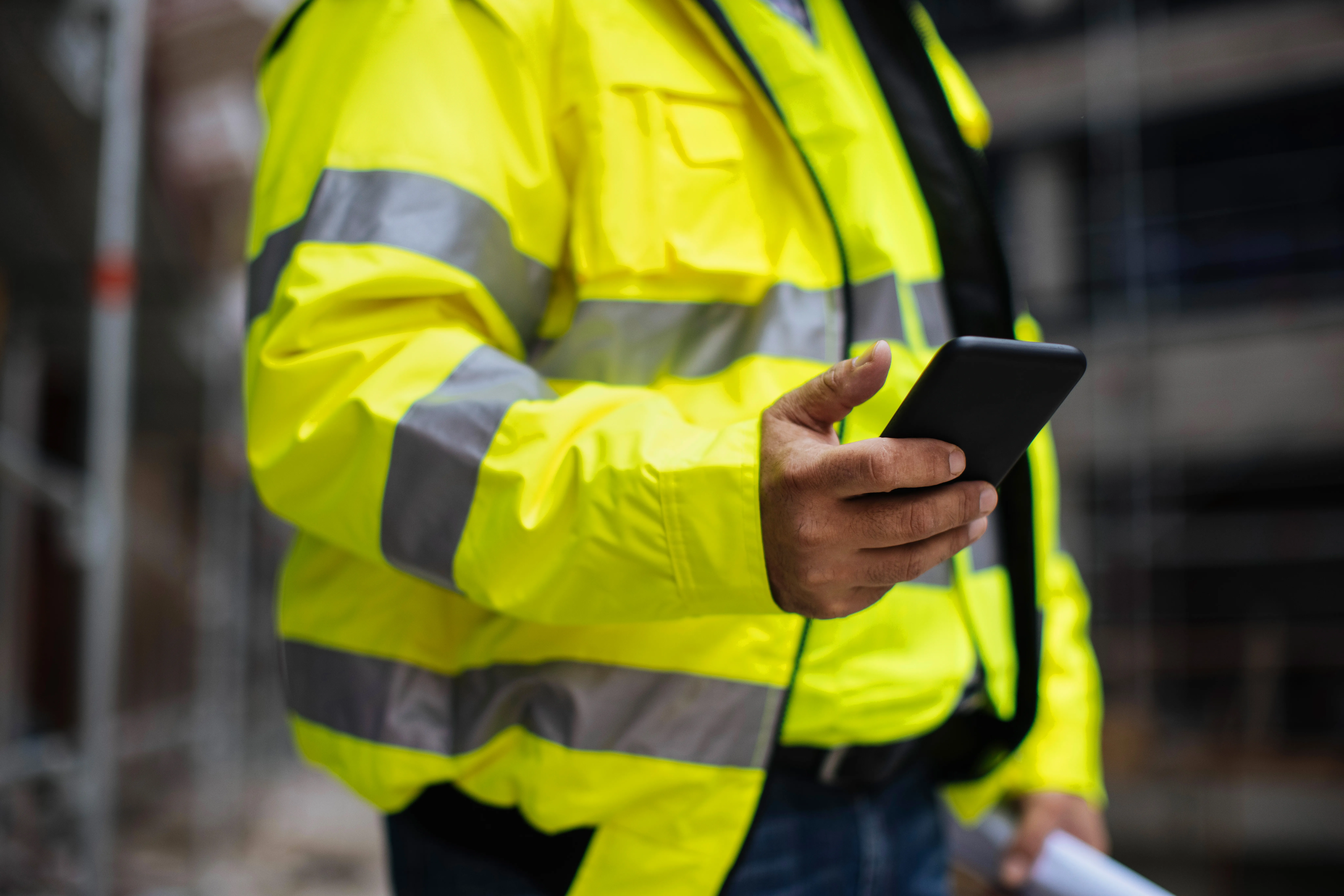 Image of construction worker holding phone